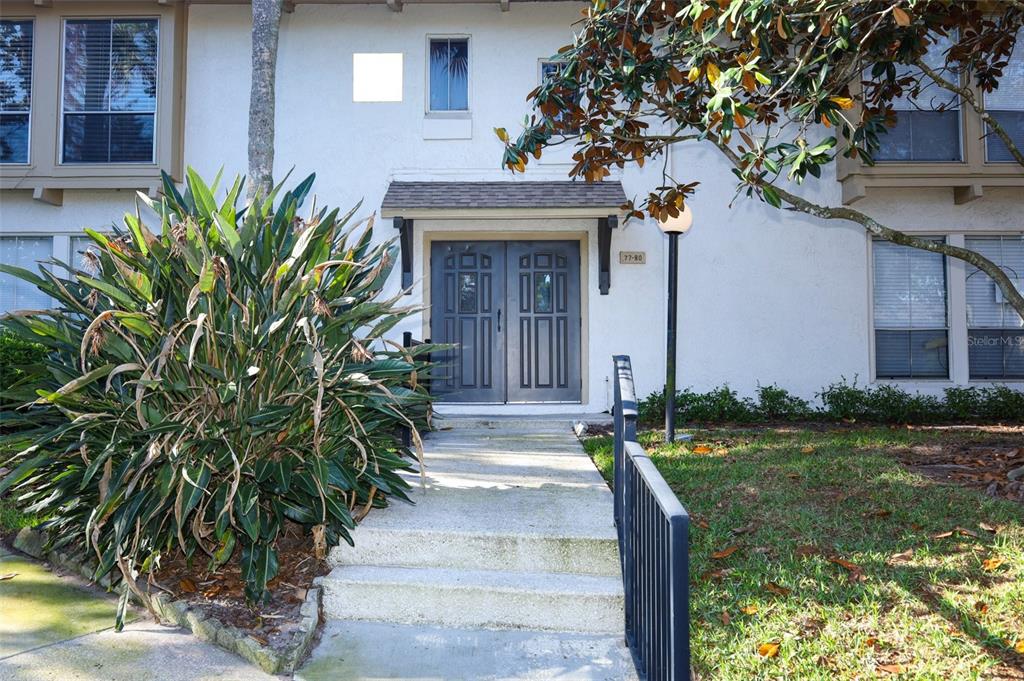A concrete walkway leads to the double front doors of a multi-story residential building — 200 MAITLAND AVENUE UNIT 78, ALTAMONTE SPRINGS, FL