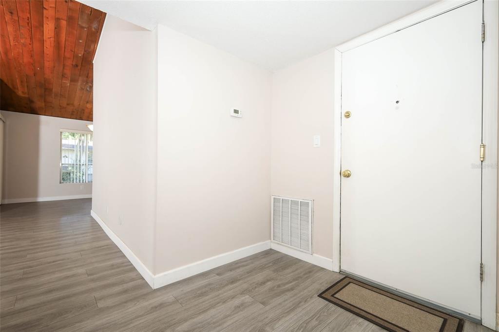An entryway features light-colored walls, gray wood-look flooring, a white front door, and a vent — 200 MAITLAND AVENUE UNIT 78, ALTAMONTE SPRINGS, FL
