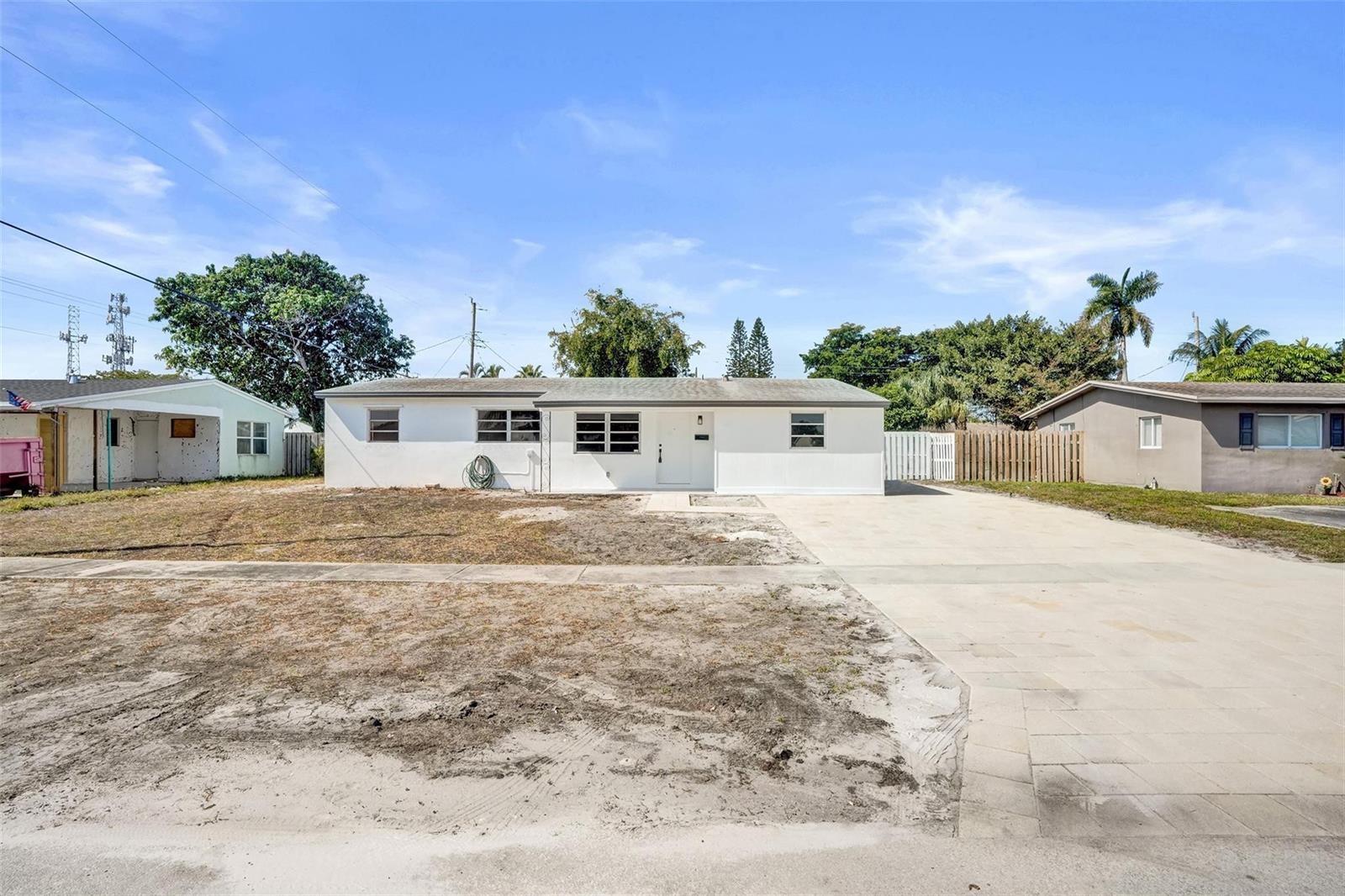 A single-story white house with a concrete driveway and a sparse front lawn — 1437 SW 1st Avenue, Deerfield Beach FL 33441, DEERFIELD BEACH, FL