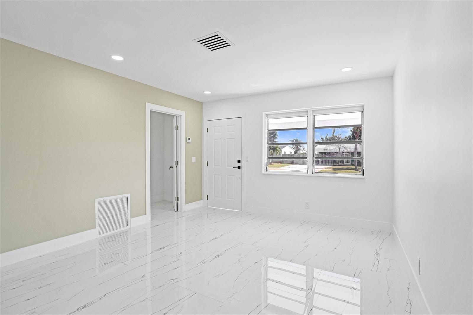 A bright room with white marble-look tile flooring, a light green accent wall, and windows — 1437 SW 1st Avenue, Deerfield Beach FL 33441, DEERFIELD BEACH, FL