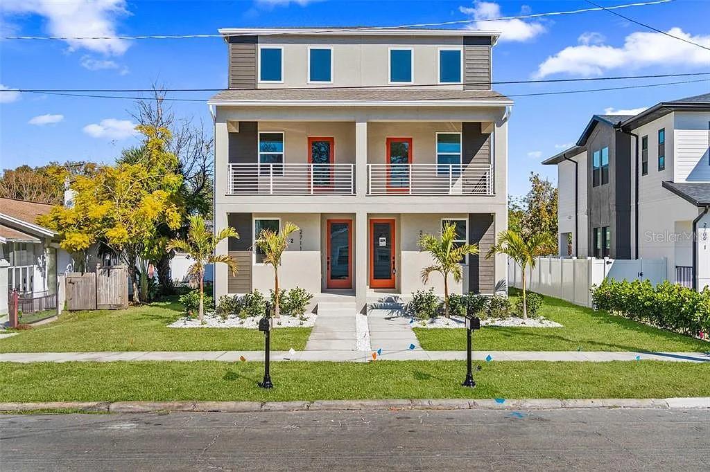 A three-story duplex features orange front doors, white railings, and small palm trees — 1541 W LA SALLE STREET, TAMPA, FL