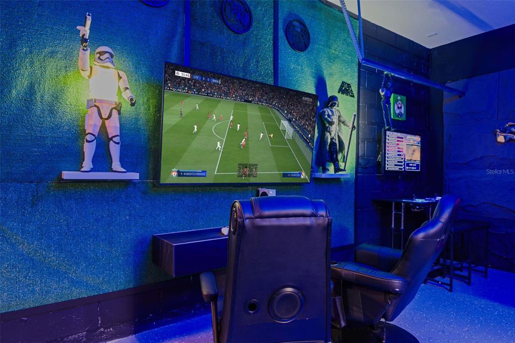 A Star Wars-themed game room features a large television, gaming chairs, and wall-mounted character figures — 7796 SOMERSWORTH DRIVE, KISSIMMEE, FL