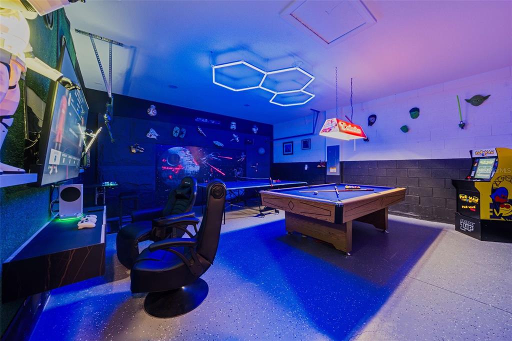A game room features a pool table, Pac-Man arcade cabinet, gaming chairs, and Star Wars decor — 7796 SOMERSWORTH DRIVE, KISSIMMEE, FL