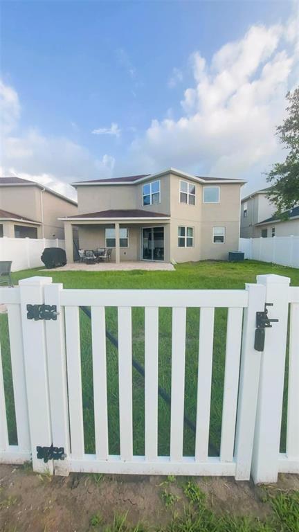 The exterior view shows the back of a two-story house with a covered patio — 11542 BRIGHTON KNOLL LOOP, RIVERVIEW, FL