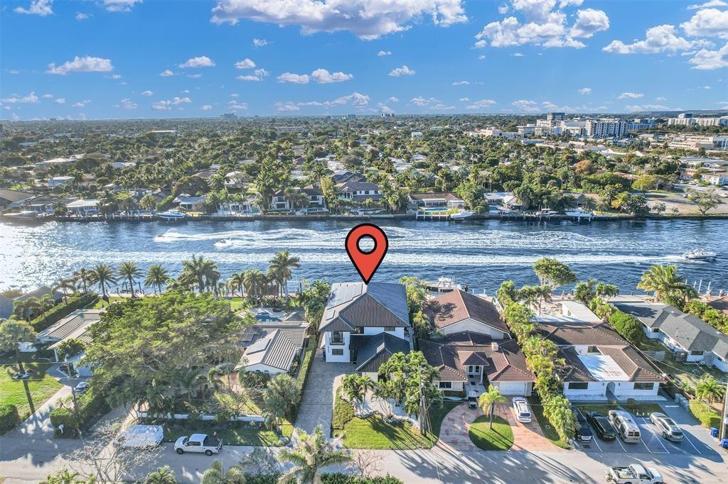 An aerial view shows a waterfront house with a dark roof and a red location pin — 319 S Riverside Drive, Pompano Beach FL 33062, POMPANO BEACH, FL