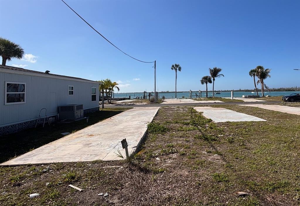 A vacant concrete pad sits next to a mobile home overlooking a coastal waterway — 7500 PARK POINTE DRIVE UNIT 53, ENGLEWOOD, FL