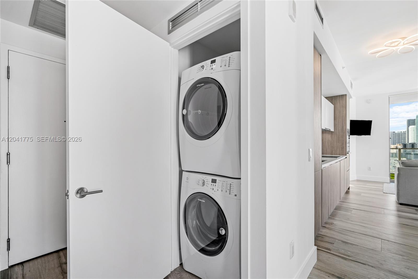 A stacked washer and dryer unit is located in a closet next to a kitchen — 2900 NE 7th Ave # 1609, Miami FL 33137, MIAMI, FL