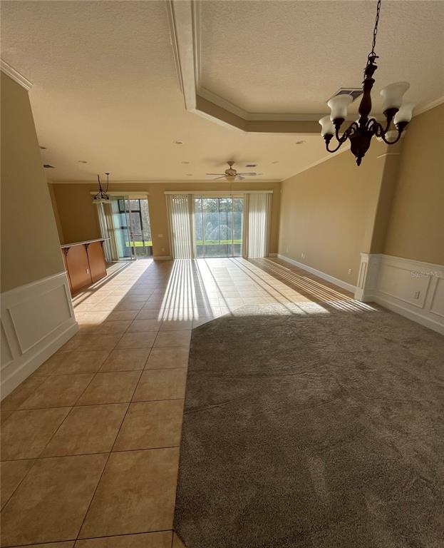 A spacious living area features tile flooring, a carpeted section, and large sliding glass doors — 8314 VIA VERONA, ORLANDO, FL