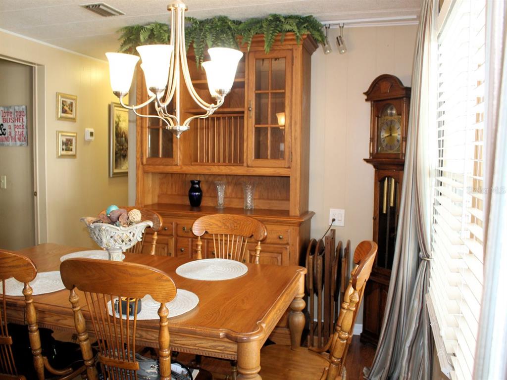 A dining room features a wooden table, chairs, a hutch, and a grandfather clock — 26 ROYAL PALM CIRCLE, LARGO, FL