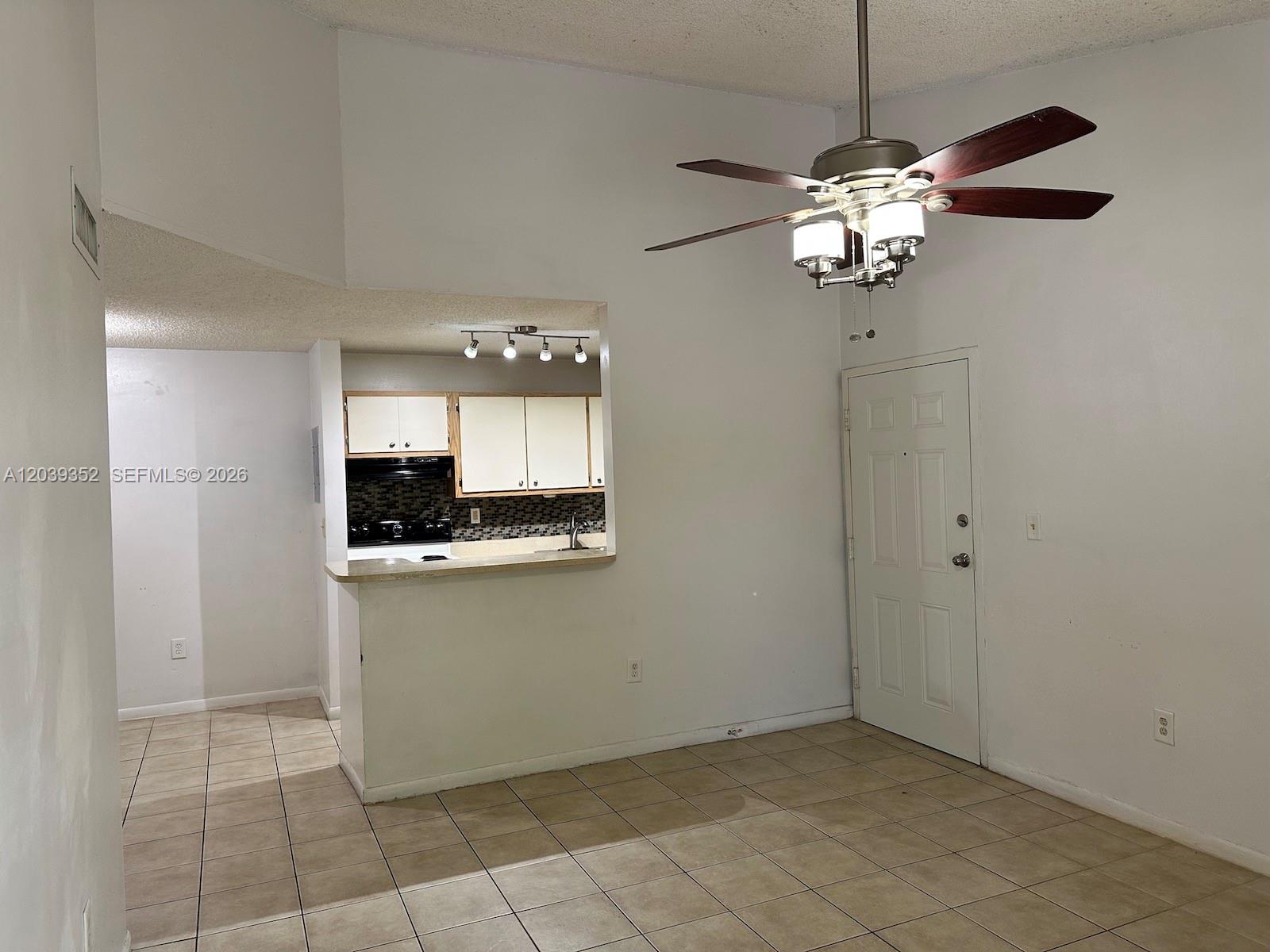 An open-concept dining area with tile floors, a ceiling fan, and a pass-through kitchen — 7200 NW 179th St # 311, Hialeah FL 33015, HIALEAH, FL