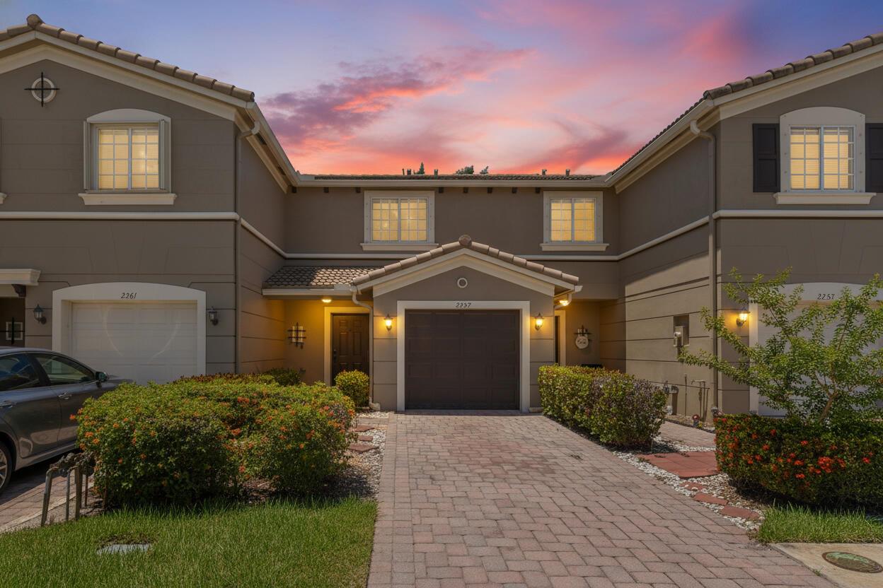 A multi-unit residential building with a paved driveway, garage doors, and landscaped front yard — 2257 SW Marshfield Court, FL 34953, FL