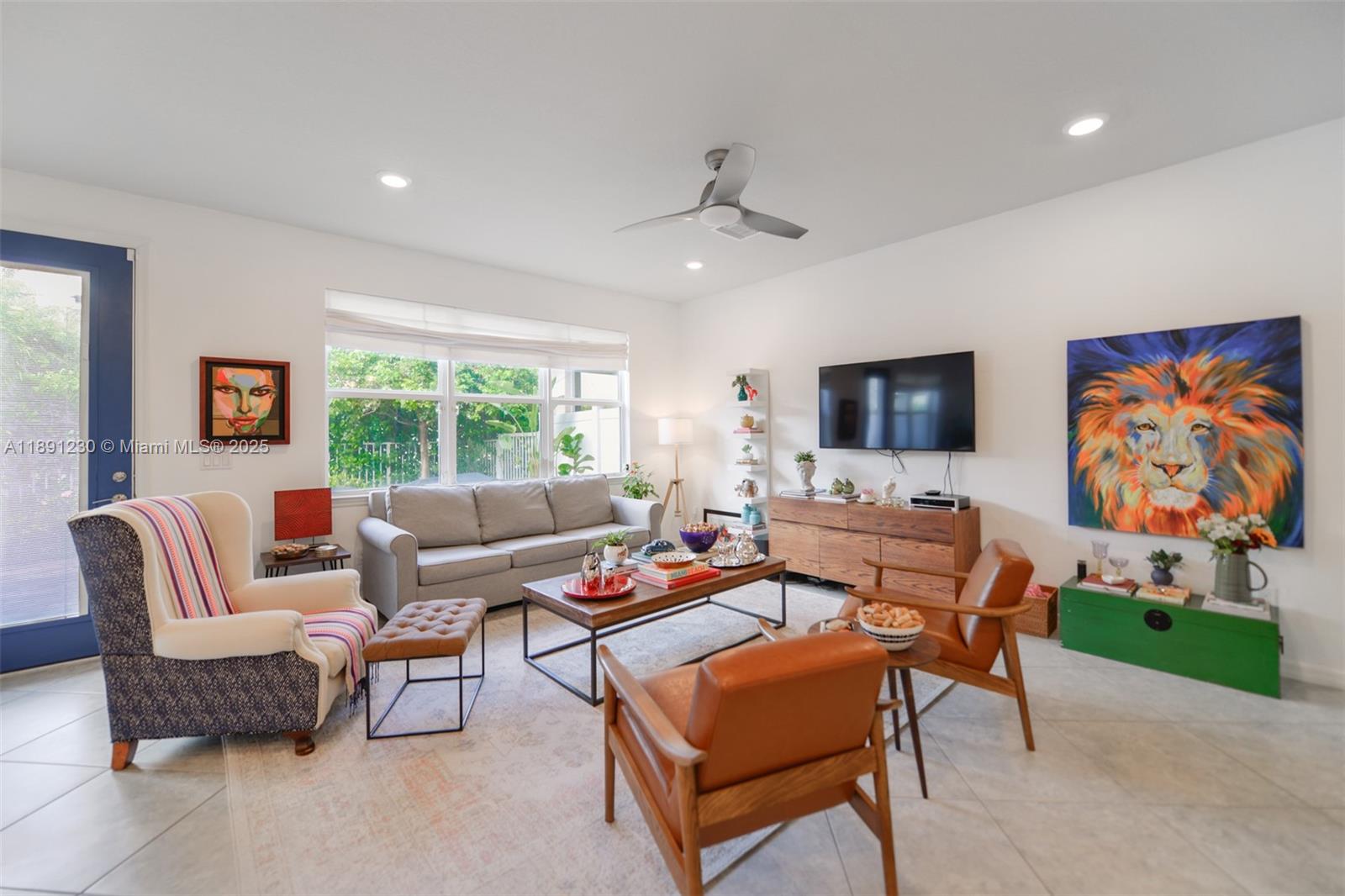 A living room features a gray sofa, two leather chairs, and a large lion painting — 4735 Eucalyptus Dr, Hollywood FL 33021, HOLLYWOOD, FL