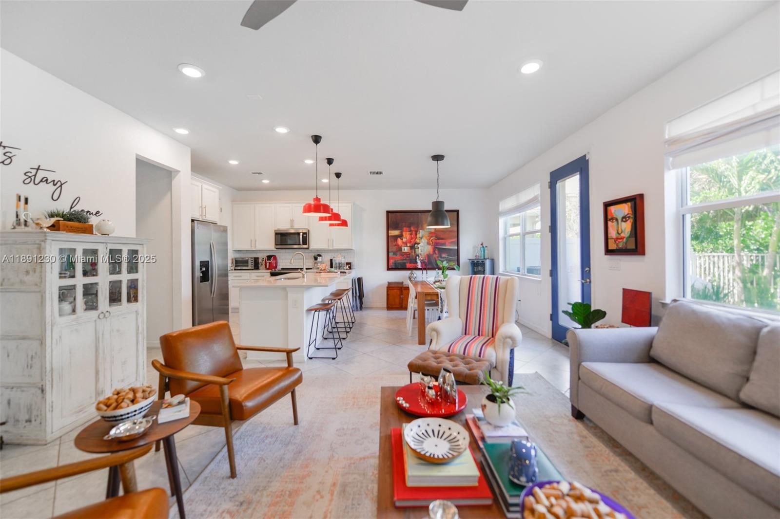 An open-concept living and dining area features a kitchen island, white cabinetry, and tile flooring — 4735 Eucalyptus Dr, Hollywood FL 33021, HOLLYWOOD, FL
