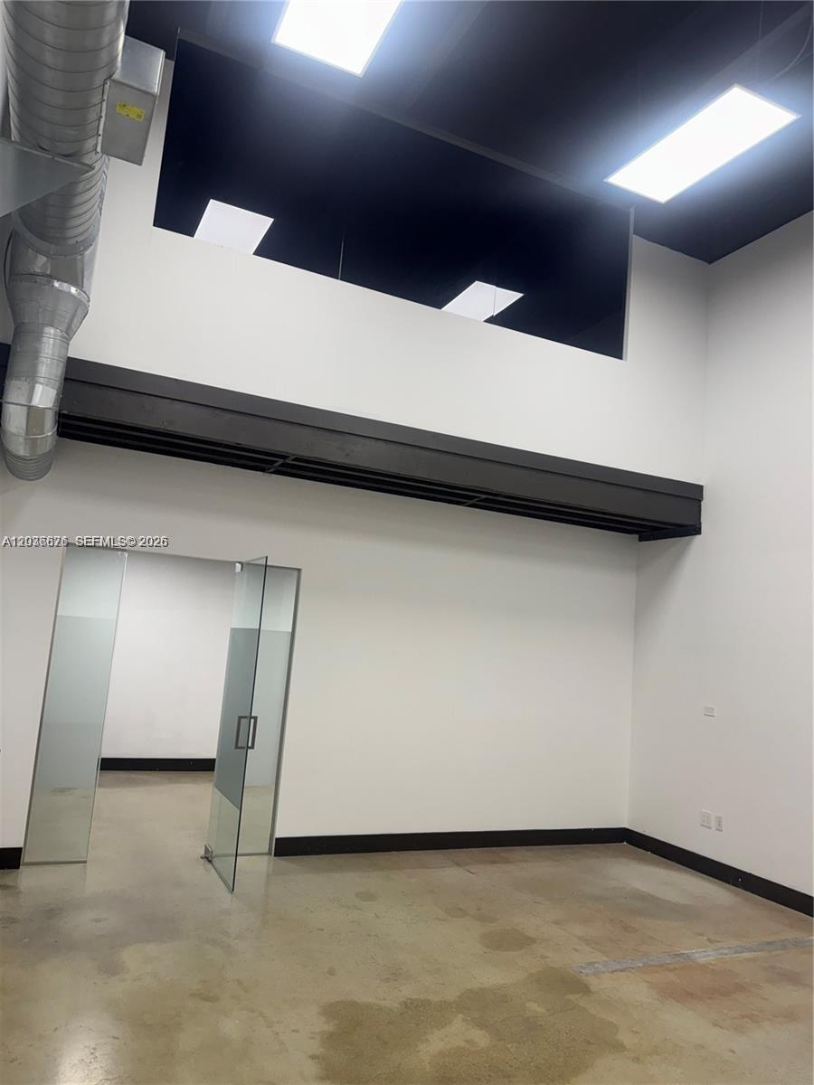 A modern office space features white walls, a glass door, and exposed industrial ductwork — 10171 NW 58th St # 6, Doral FL 33178, DORAL, FL