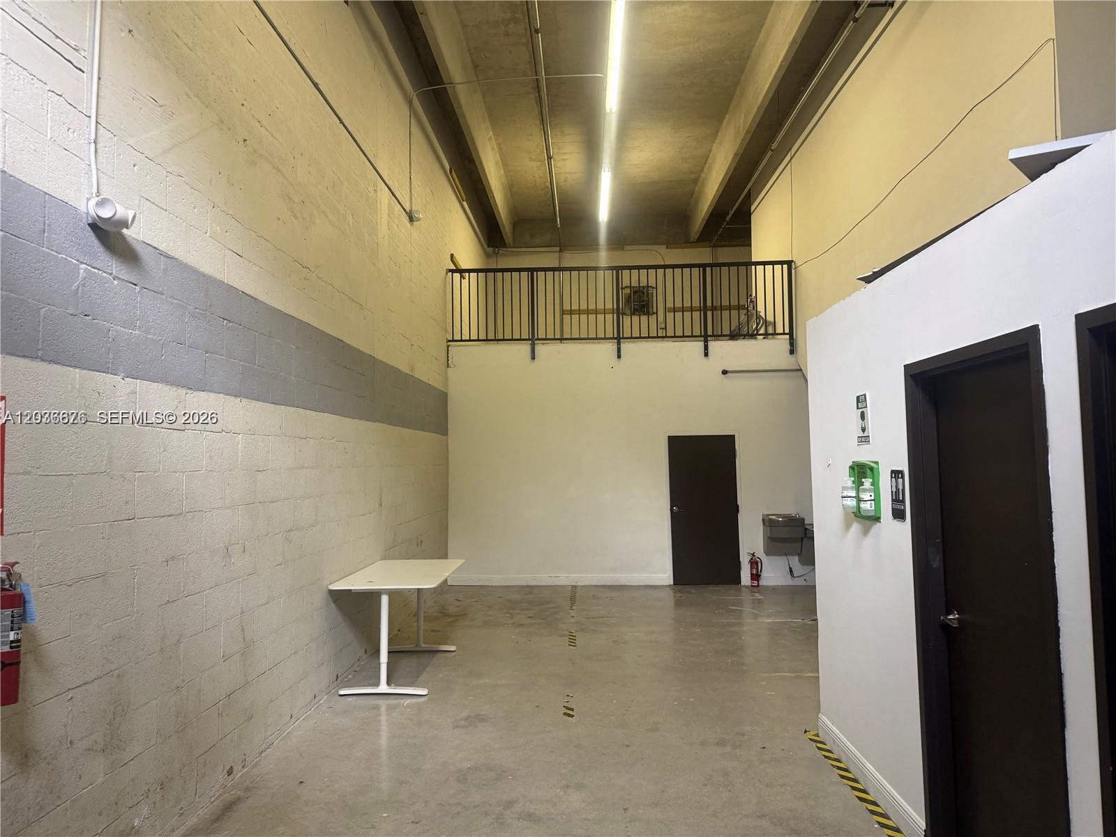 An industrial warehouse space features a concrete floor, high ceilings, a mezzanine, and a restroom — 10171 NW 58th St # 6, Doral FL 33178, DORAL, FL