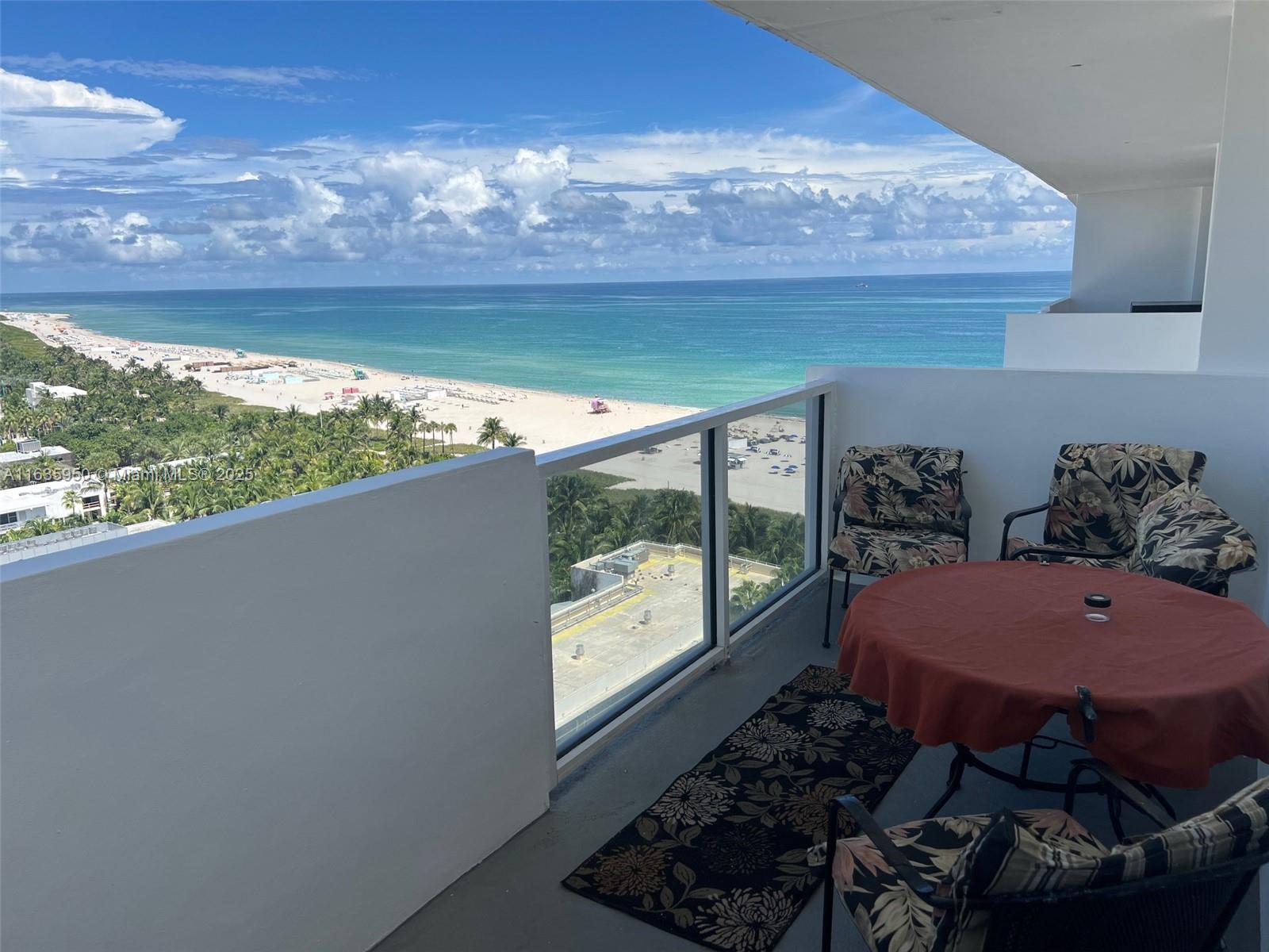 A balcony with patio furniture overlooks a sandy beach and the ocean — 100 Lincoln Rd # 1633, Miami Beach FL 33139, MIAMI BEACH, FL