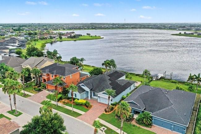 An aerial view shows several suburban houses situated along the shore of a large lake — 11323 LAKE LUCAYA DRIVE, RIVERVIEW, FL