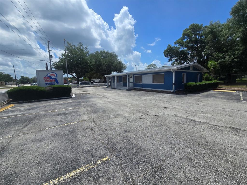 A blue commercial building with a parking lot and a Sun Coast sign — 531 DOG TRACK ROAD, LONGWOOD, FL