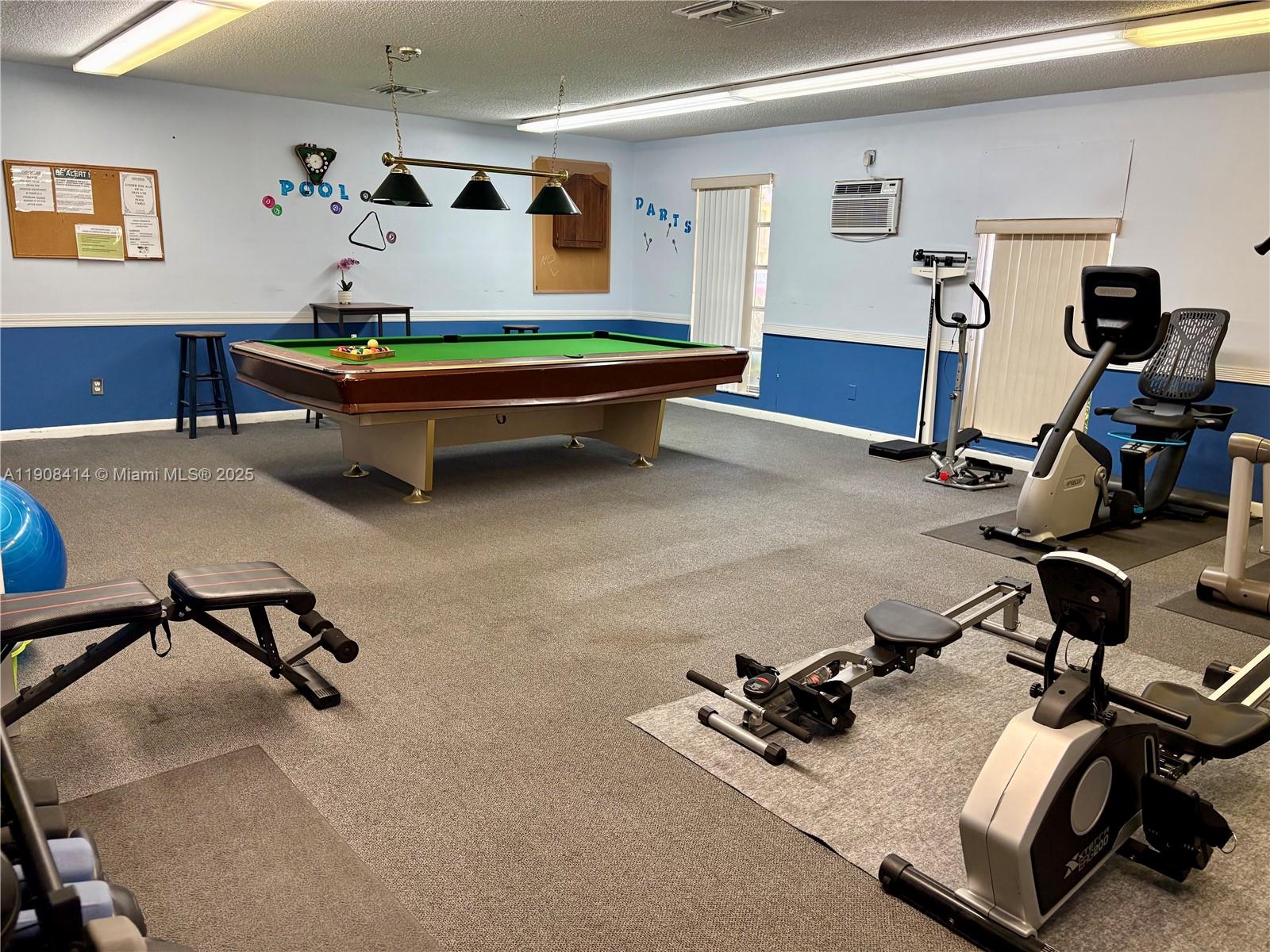 A recreation room features a pool table, exercise equipment, and blue and white walls — 7310 NW 1st St # 105, Margate FL 33063, MARGATE, FL