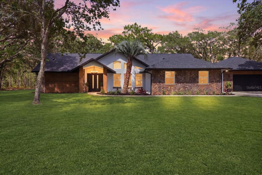 A single-story house with a stone facade, dark roof, and a prominent palm tree — 2995 N BRAVO DRIVE, BEVERLY HILLS, FL