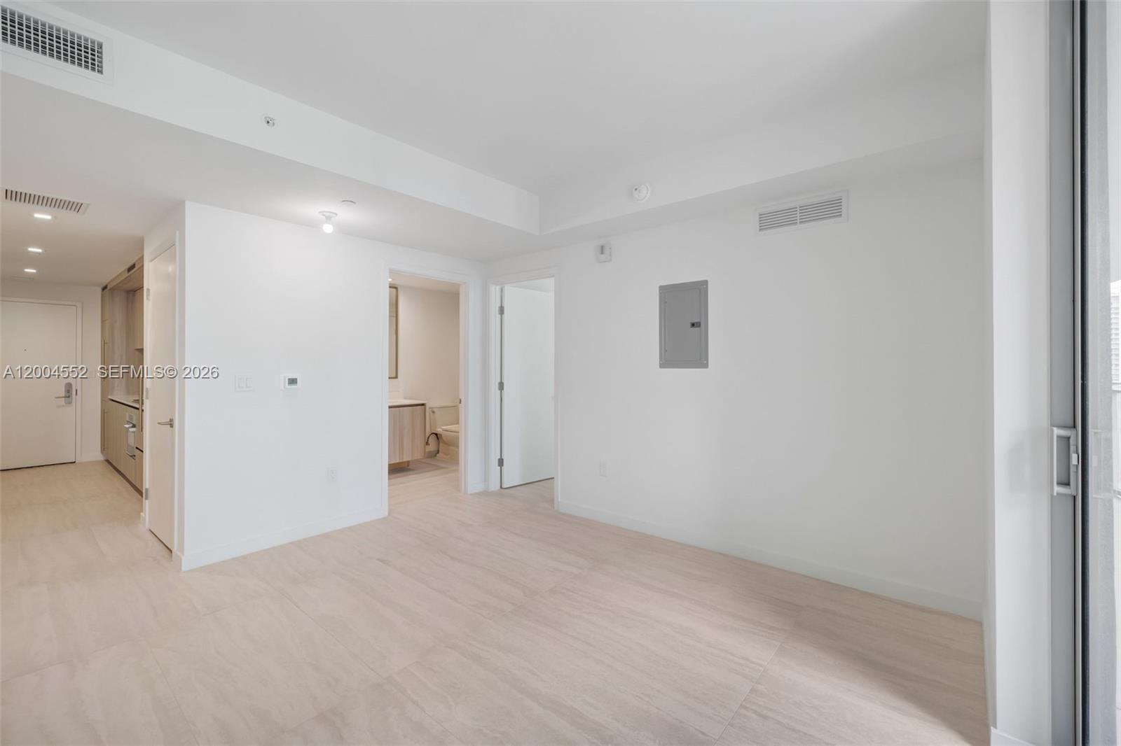An empty room with white walls, light-colored tile flooring, and two doorways leading to other areas — 77 SE 5th St # 3205, Miami FL 33131, MIAMI, FL