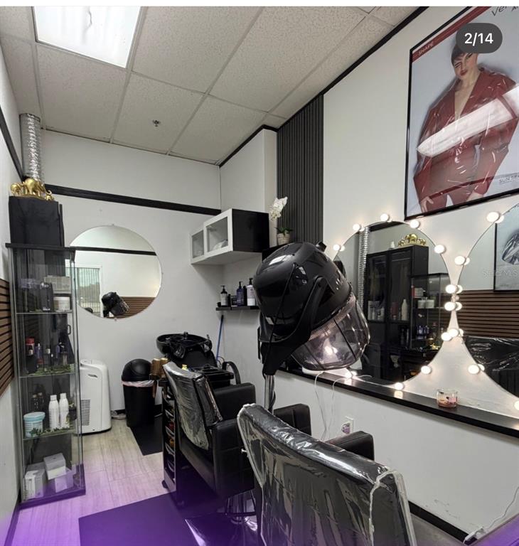 A small hair salon featuring a styling chair, a hooded dryer, and a lighted vanity mirror — 1307 E OSCEOLA PARKWAY, KISSIMMEE, FL
