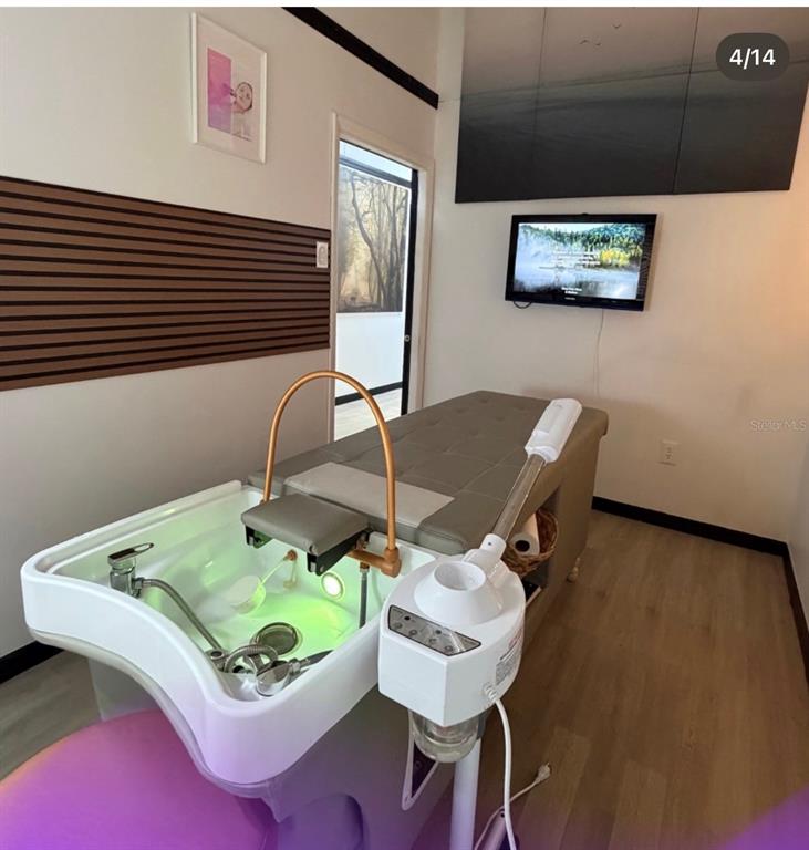 A spa treatment room features a shampoo bowl, a facial steamer, and a massage table — 1307 E OSCEOLA PARKWAY, KISSIMMEE, FL