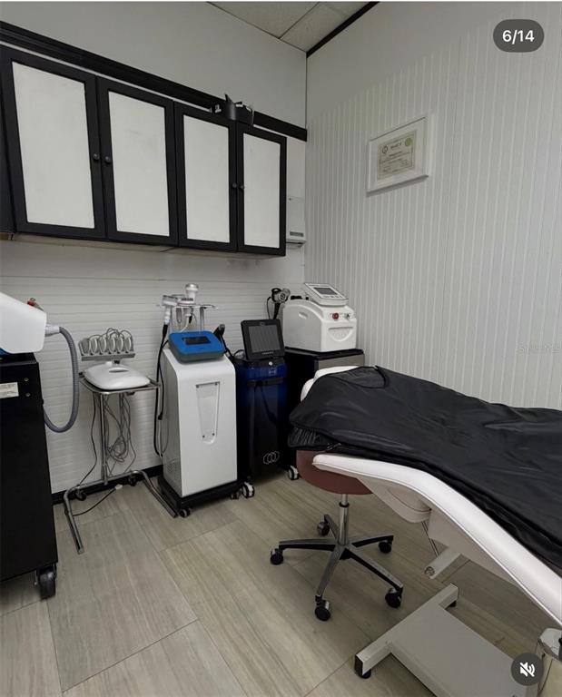A treatment room features medical aesthetic equipment, a massage table, and wall-mounted storage cabinets — 1307 E OSCEOLA PARKWAY, KISSIMMEE, FL