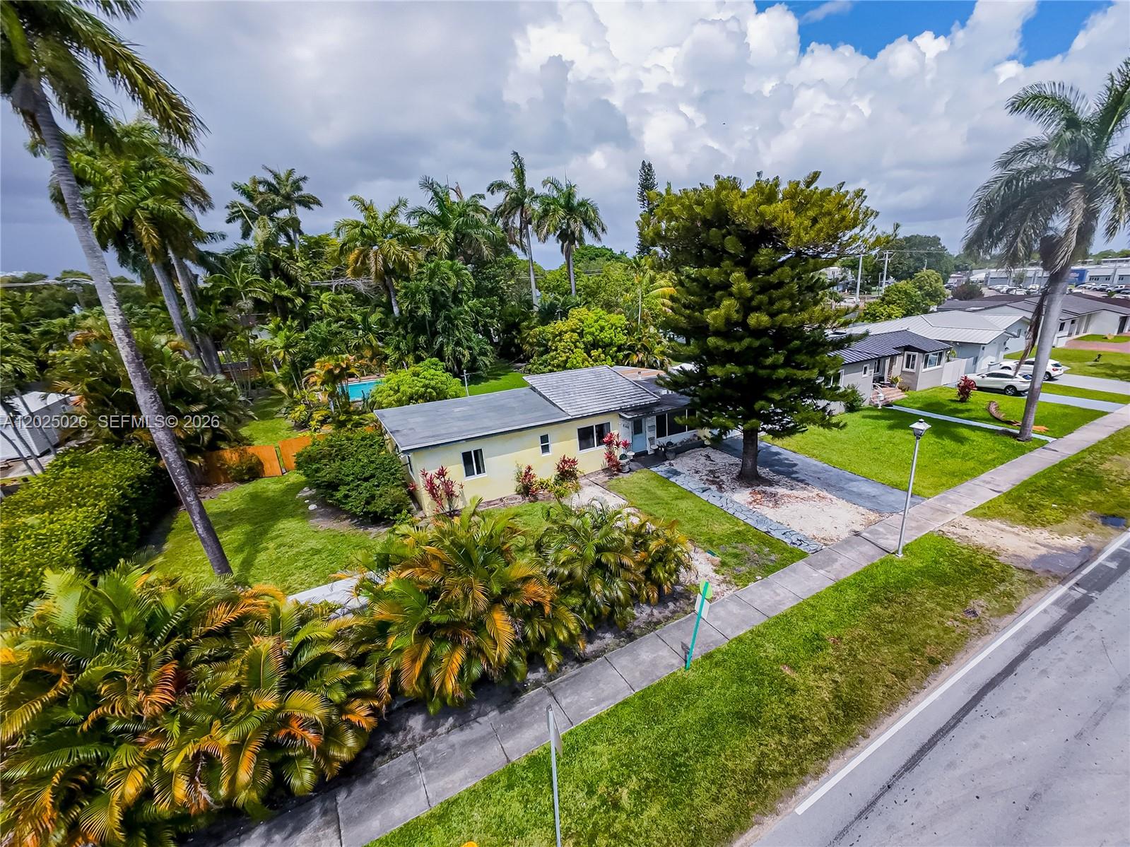 An aerial view shows a yellow single-story house with a large tree and palm trees — 548 East Dr, Miami Springs FL 33166, MIAMI SPRINGS, FL