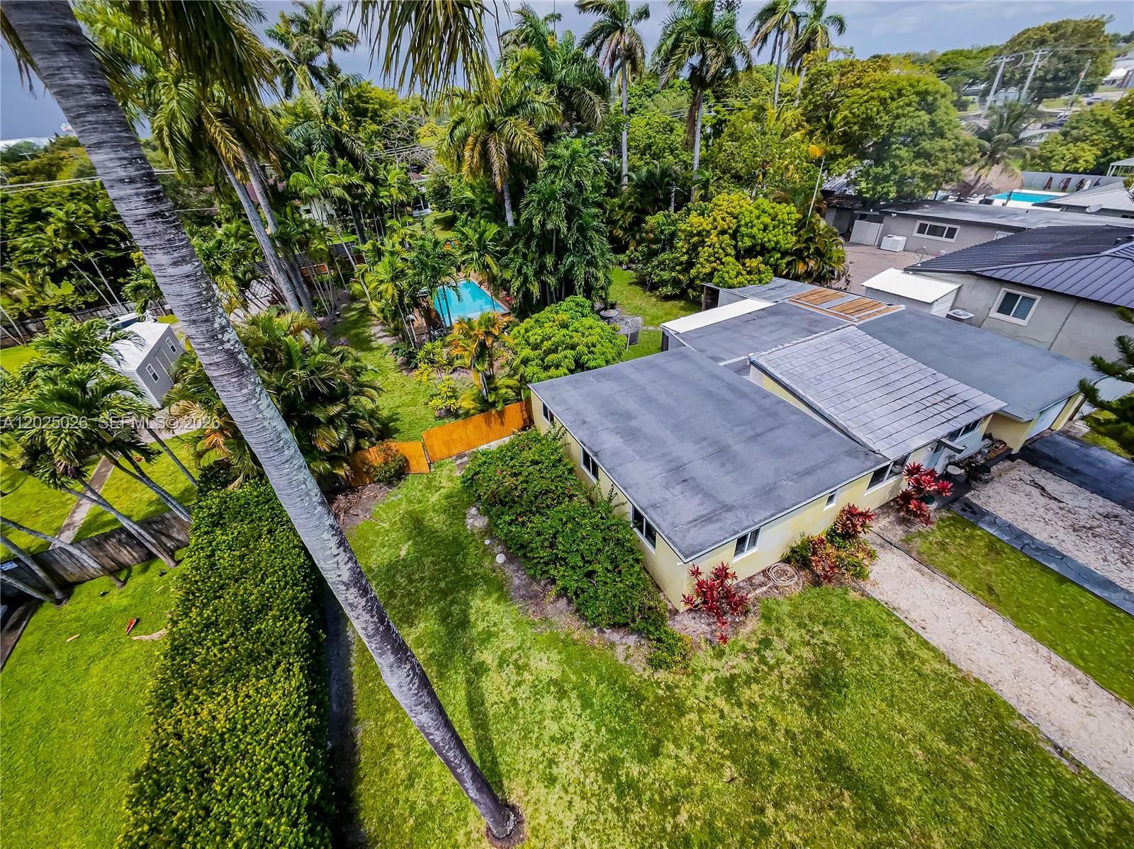 An aerial view shows a single-story house with a flat roof, pool, and palm trees — 548 East Dr, Miami Springs FL 33166, MIAMI SPRINGS, FL