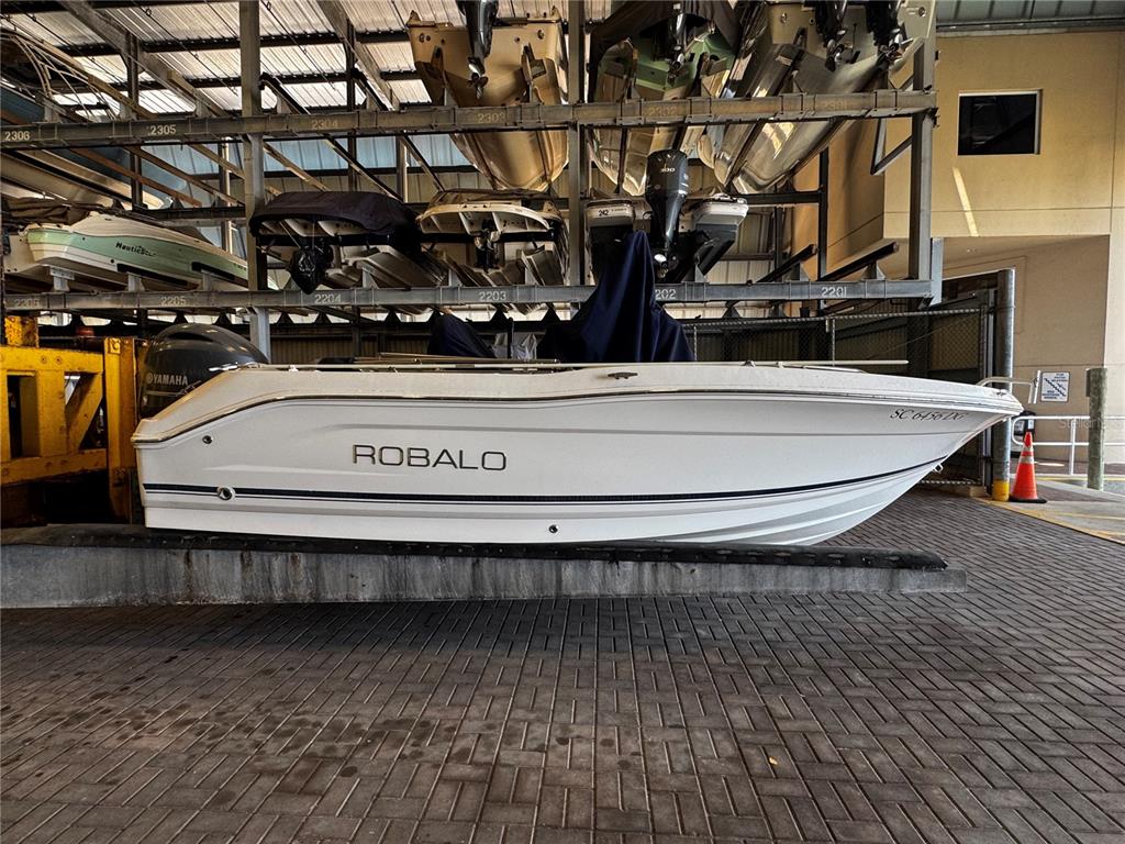 A white Robalo boat sits on a rack in a dry storage facility — 408 GULF OF MEXICO DRIVE UNIT 1214, LONGBOAT KEY, FL