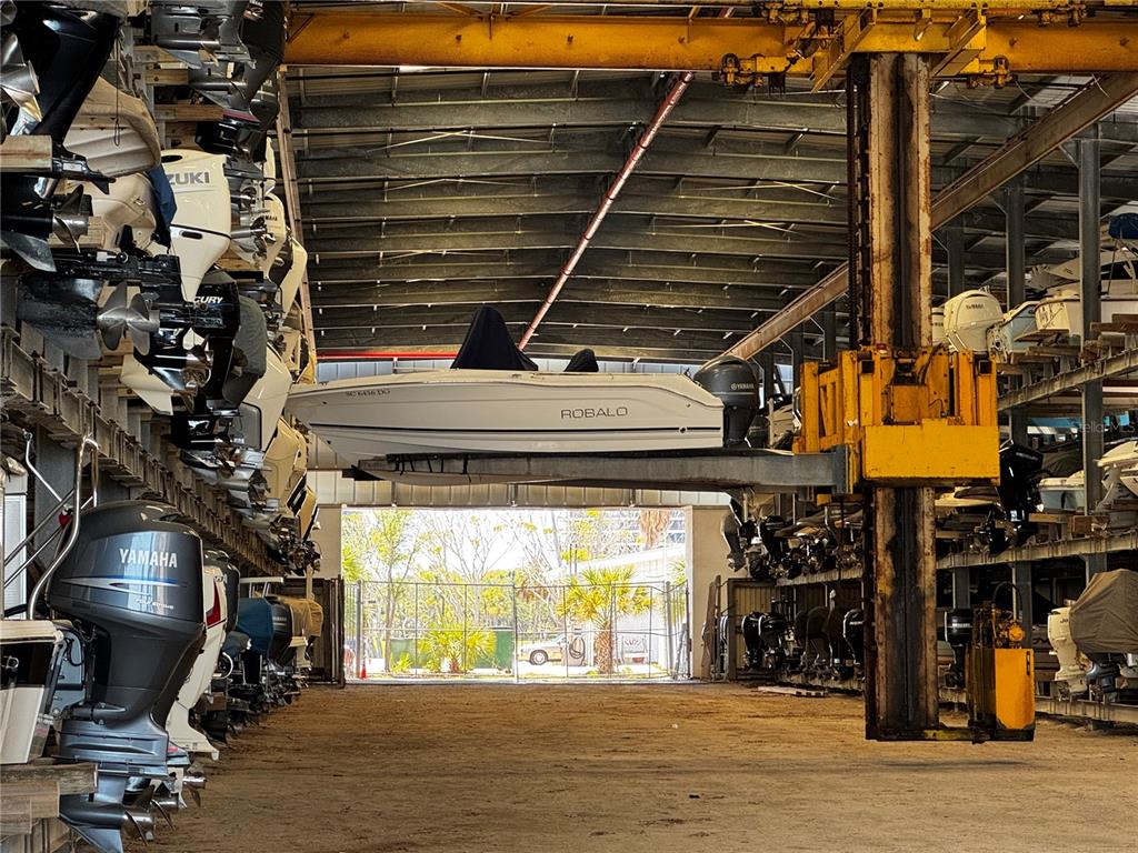 A boat storage facility features stacked boats on metal racks and a large forklift — 408 GULF OF MEXICO DRIVE UNIT 1214, LONGBOAT KEY, FL