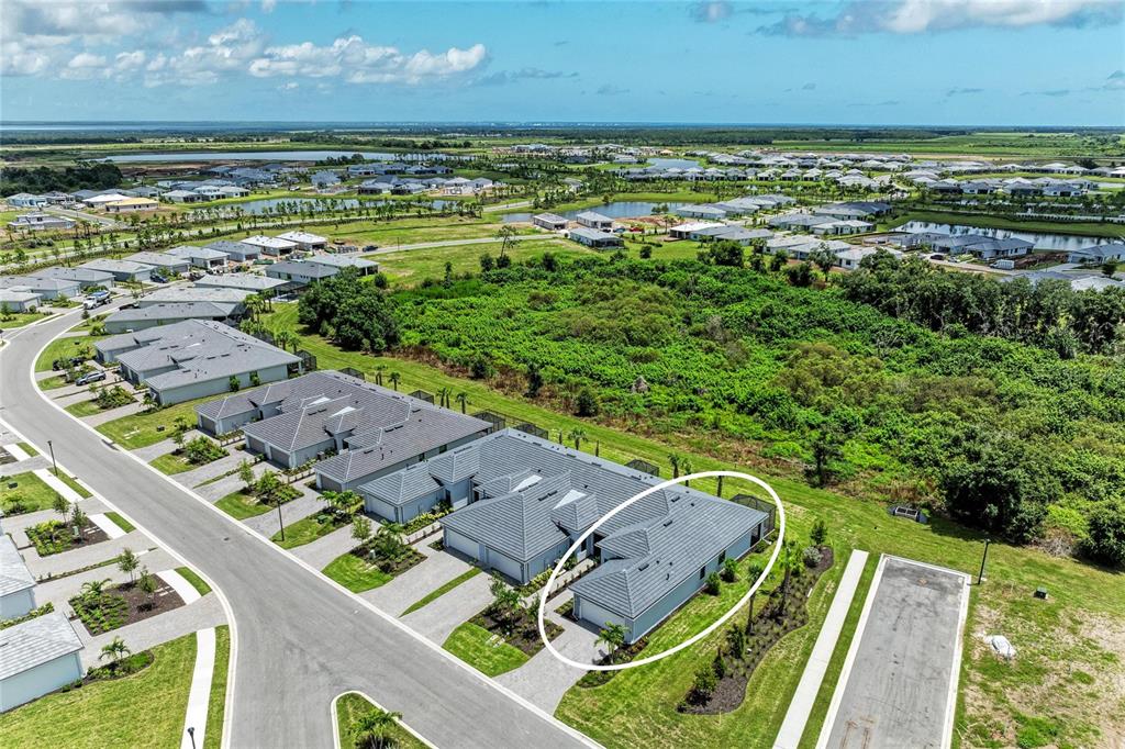 An aerial view shows a single-story residential home with a gray roof and attached garage — 18808 INDIAN ROCK PLACE, LAKEWOOD RANCH, FL