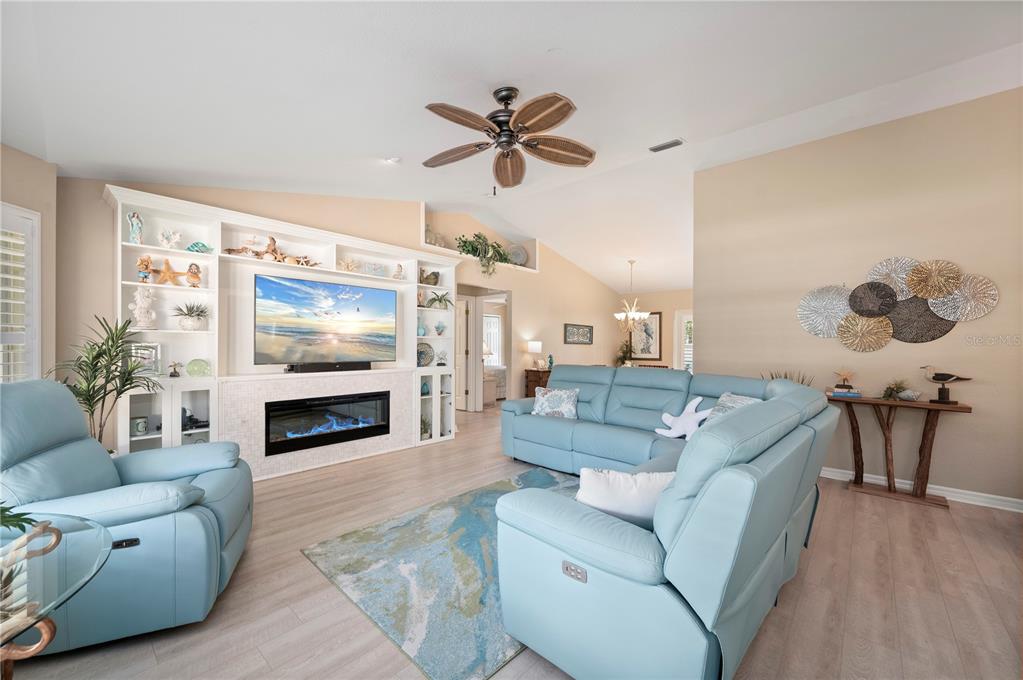A living room features light blue leather furniture, a fireplace, and built-in shelving — 23347 MULLINS AVENUE, PORT CHARLOTTE, FL