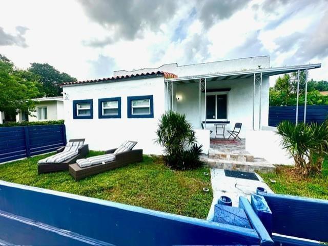 A white house with blue trim features a front lawn with two lounge chairs — 55 NW 47th Street, Miami FL 33127, MIAMI, FL