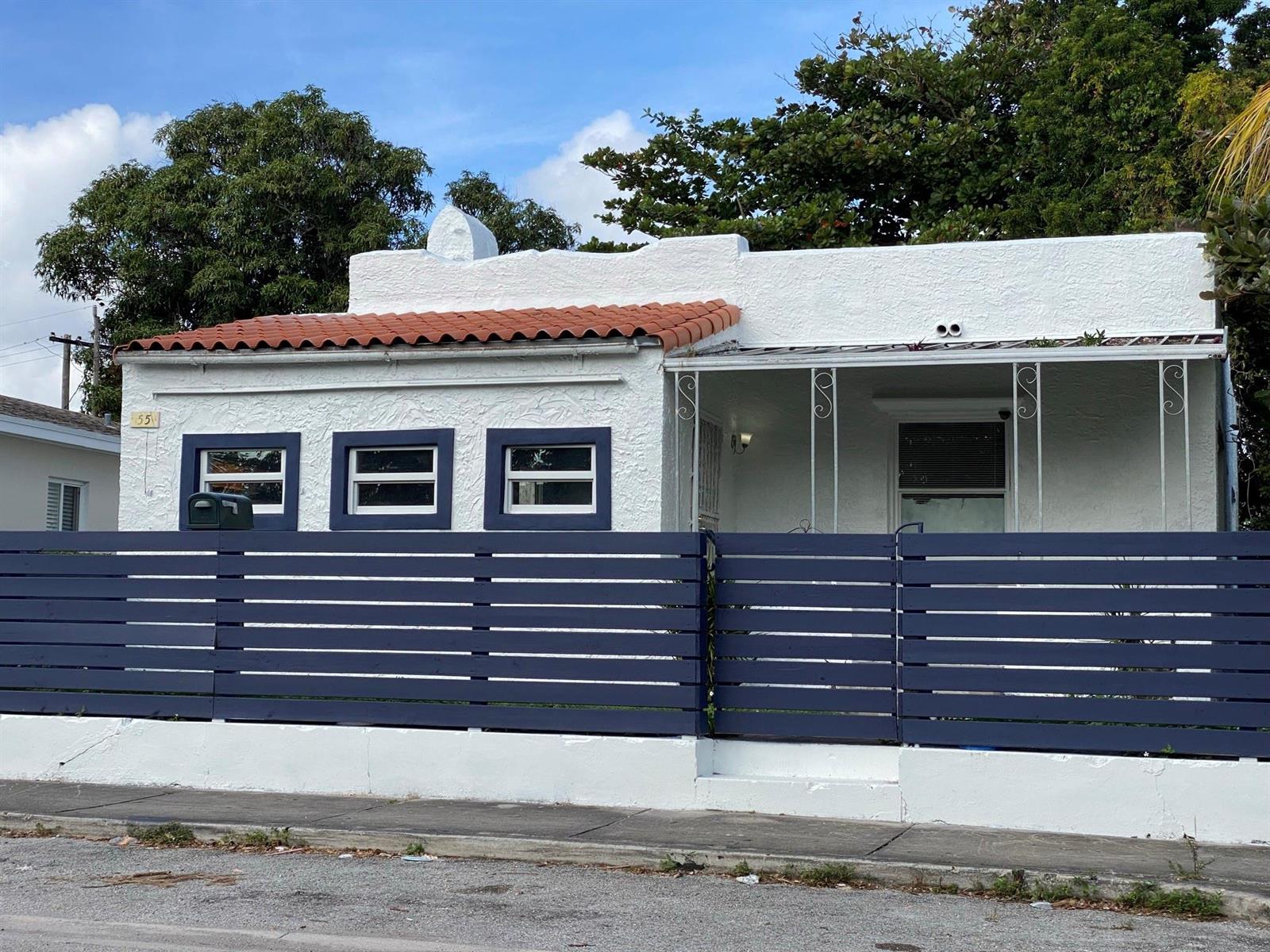 A white stucco house with a red tile roof and a dark blue horizontal fence — 55 NW 47th Street, Miami FL 33127, MIAMI, FL