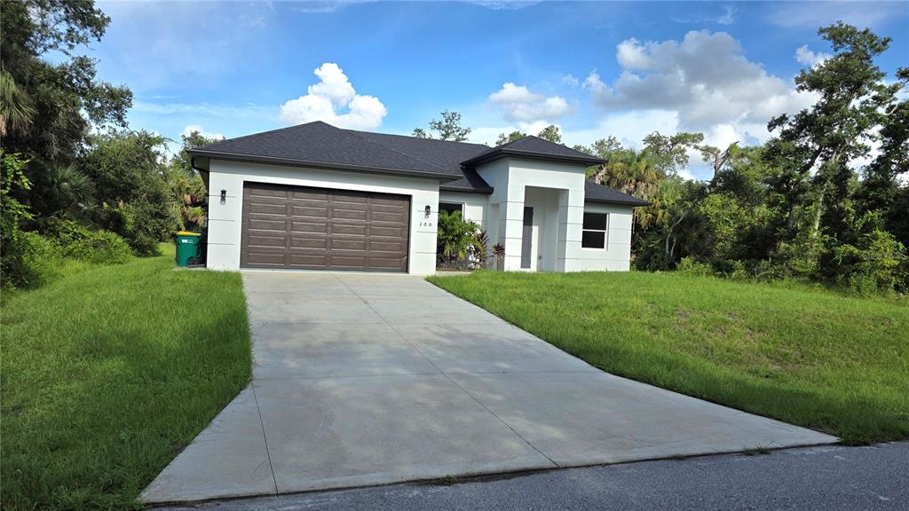 A single-story white house with a dark roof and a two-car garage — 286 KRIEGER STREET, PORT CHARLOTTE, FL