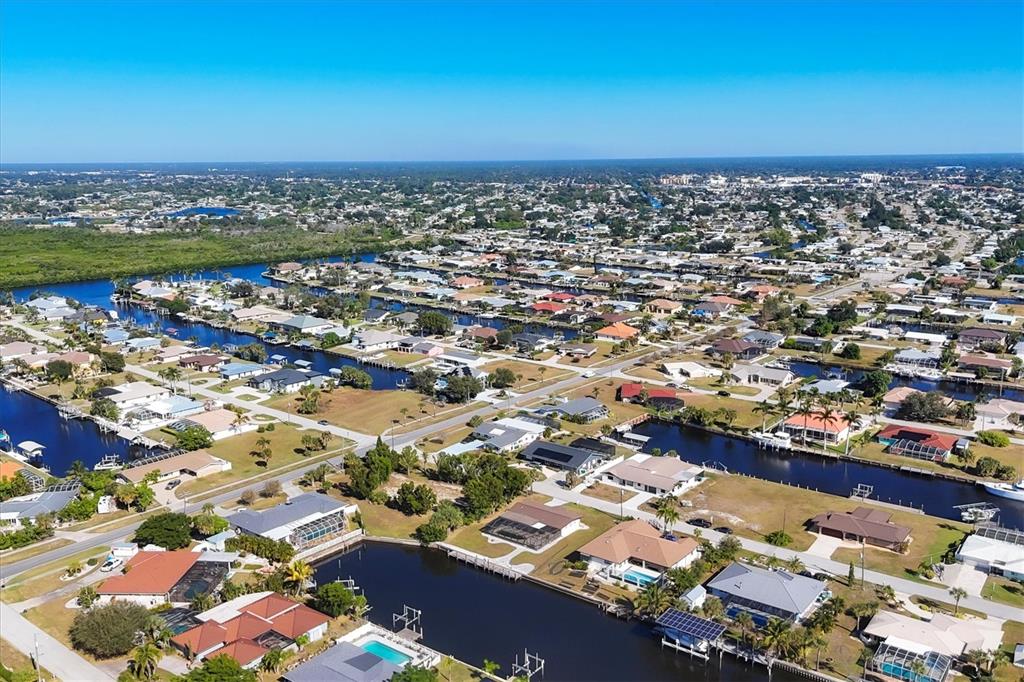 An aerial view of a residential neighborhood featuring houses with swimming pools along canals — 4358 HARBOR BOULEVARD, PORT CHARLOTTE, FL