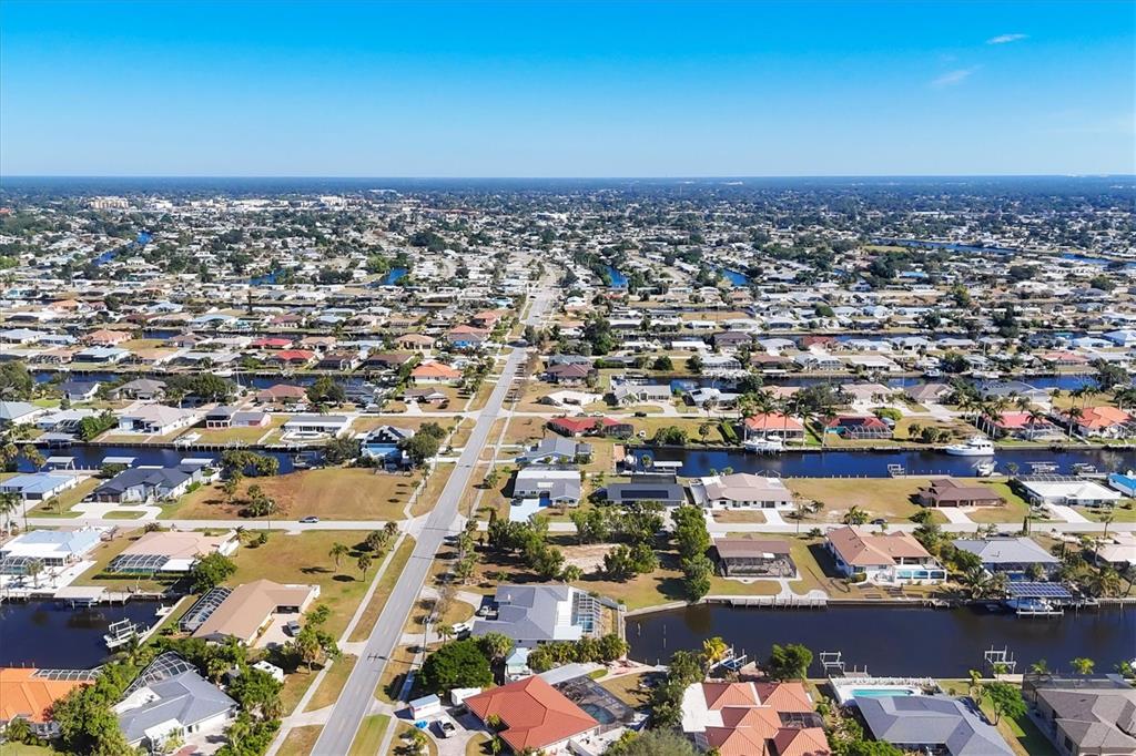 An aerial view shows a residential neighborhood with houses situated along a network of canals — 4358 HARBOR BOULEVARD, PORT CHARLOTTE, FL