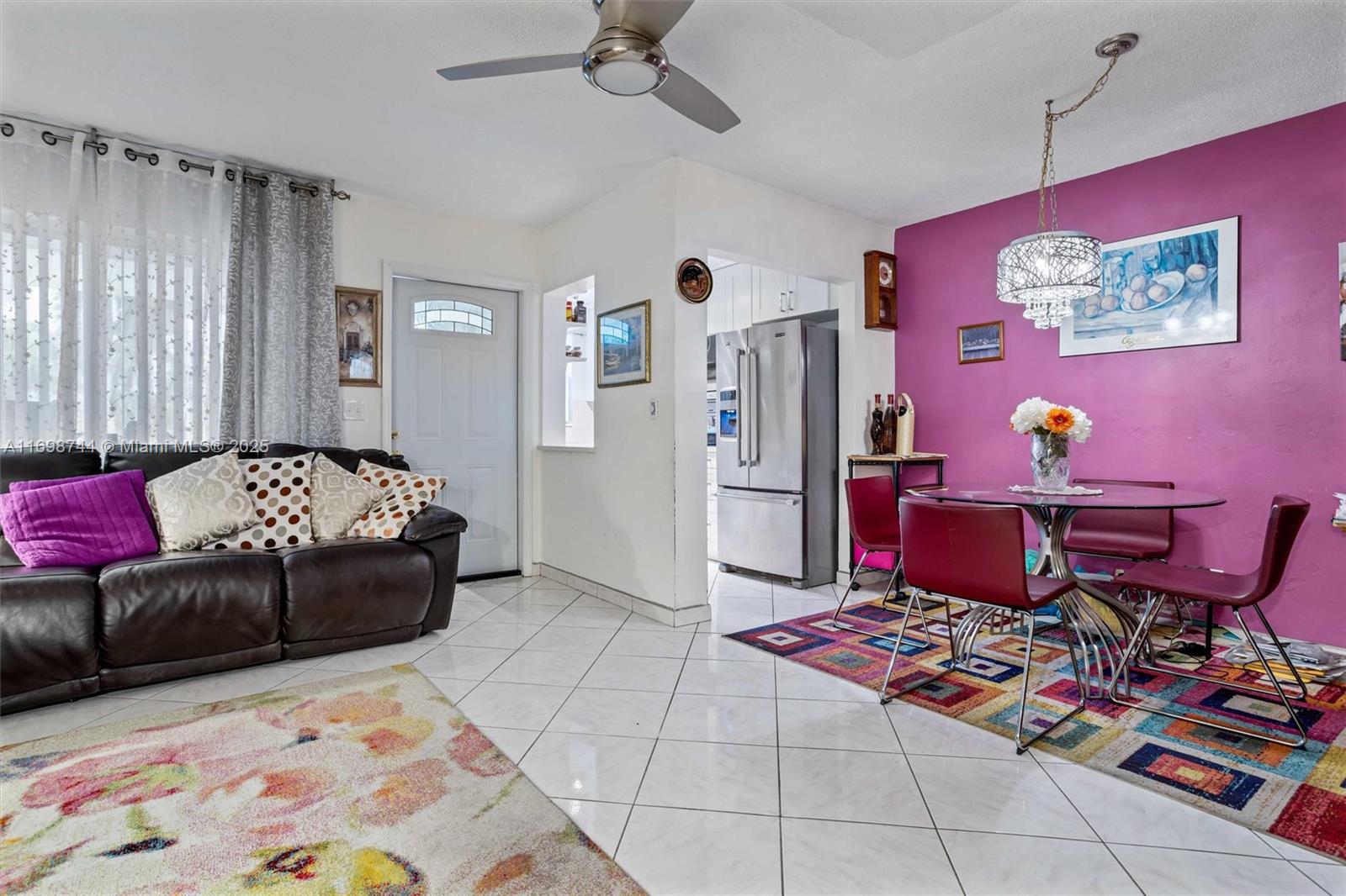 A living and dining area features a purple accent wall, tile floors, and ceiling fan — 501 Blue Heron Dr # A, Hallandale Beach FL 33009, HALLANDALE BEACH, FL