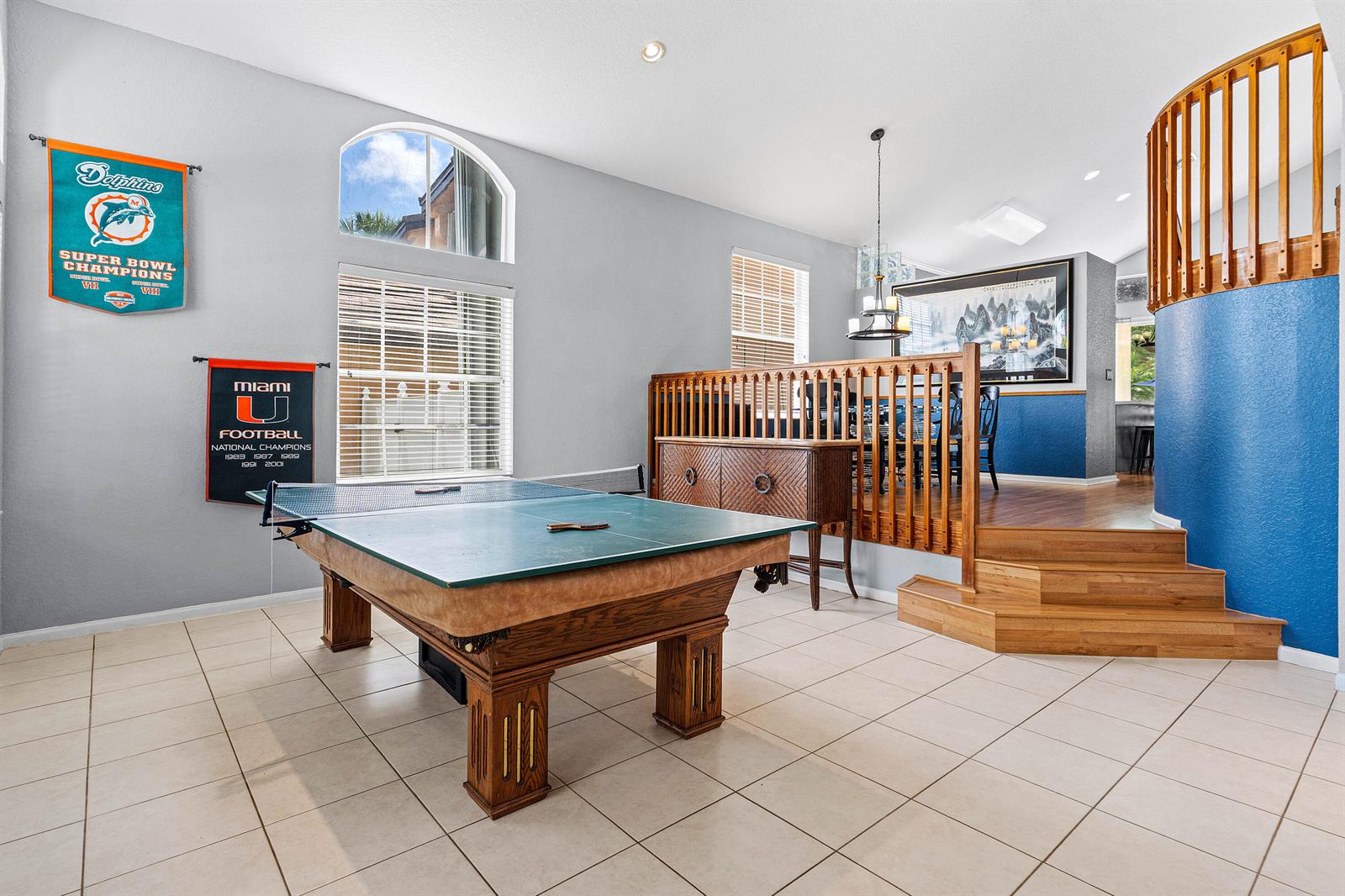 A game room features a ping pong table, tiled floors, and stairs leading to a dining area — 7872 Springvale Drive, Lake Worth FL 33467, LAKE WORTH, FL