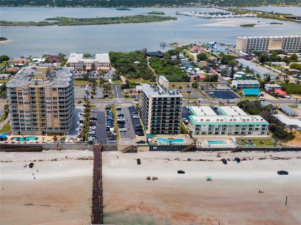 An aerial view shows two high-rise buildings and a low-rise hotel along a sandy beach — 3647 S ATLANTIC AVENUE UNIT 6G, DAYTONA BEACH SHORES, FL