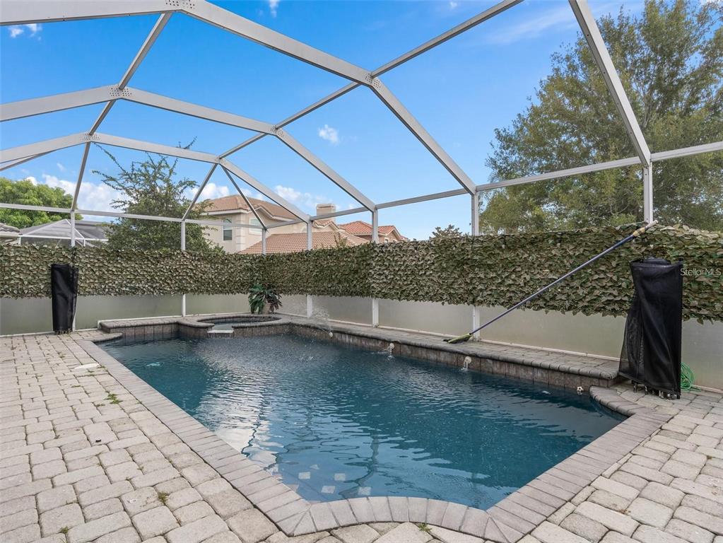 A rectangular swimming pool with a spa is enclosed by a screened lanai — 426 VISTA LOOP, DAVENPORT, FL