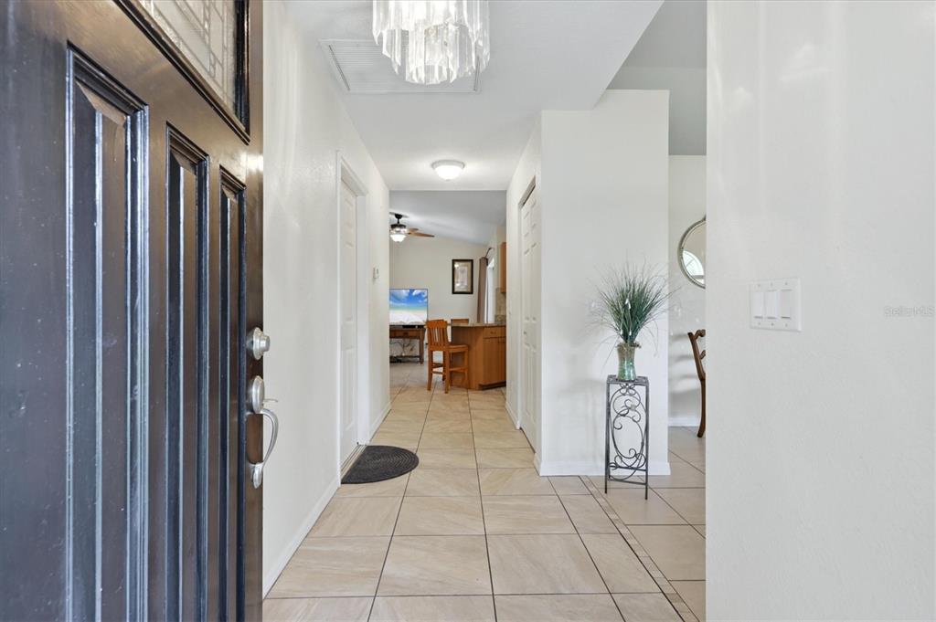 A tiled entryway leads into a home with a kitchen visible in the background — 650 CHEVY CHASE STREET, PORT CHARLOTTE, FL