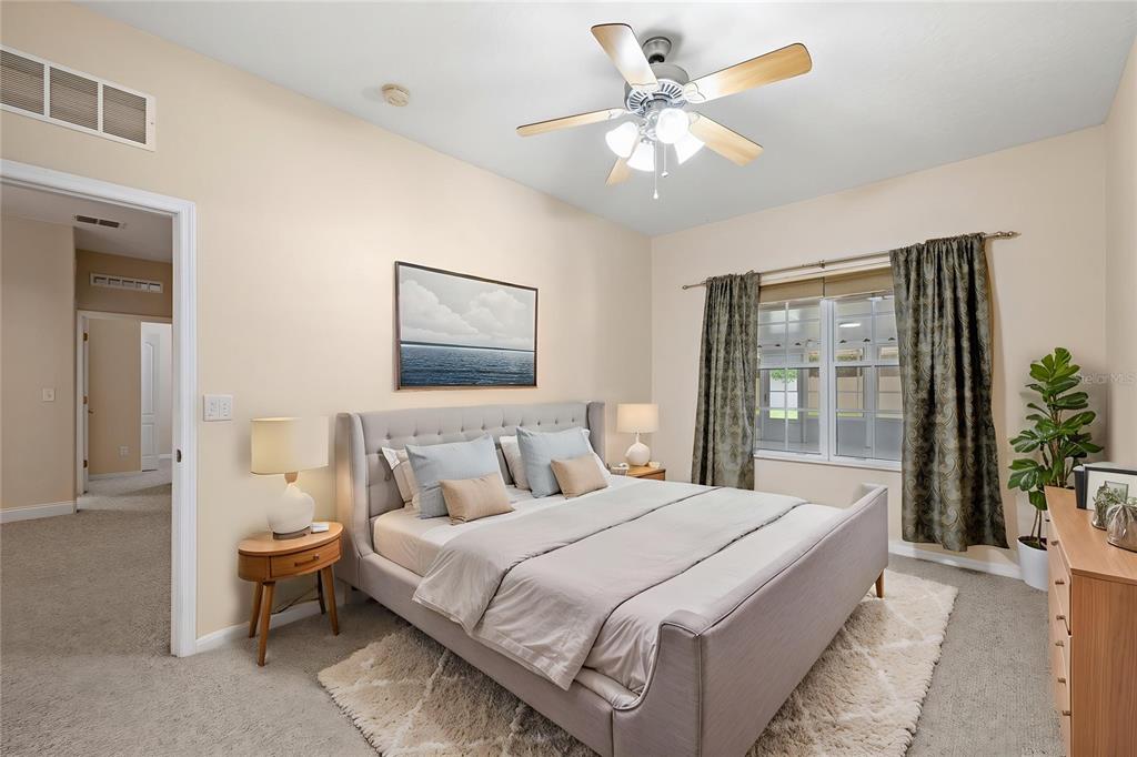 A bedroom features a gray upholstered bed, a ceiling fan, and a window with curtains — 1557 BLACKWOOD AVENUE, GOTHA, FL
