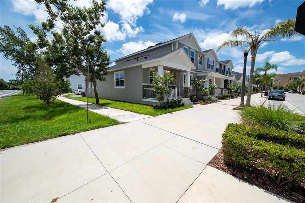 A side view of a multi-story townhouse with a front porch and concrete driveway — 189 BEAR SPRINGS DRIVE, WINTER SPRINGS, FL