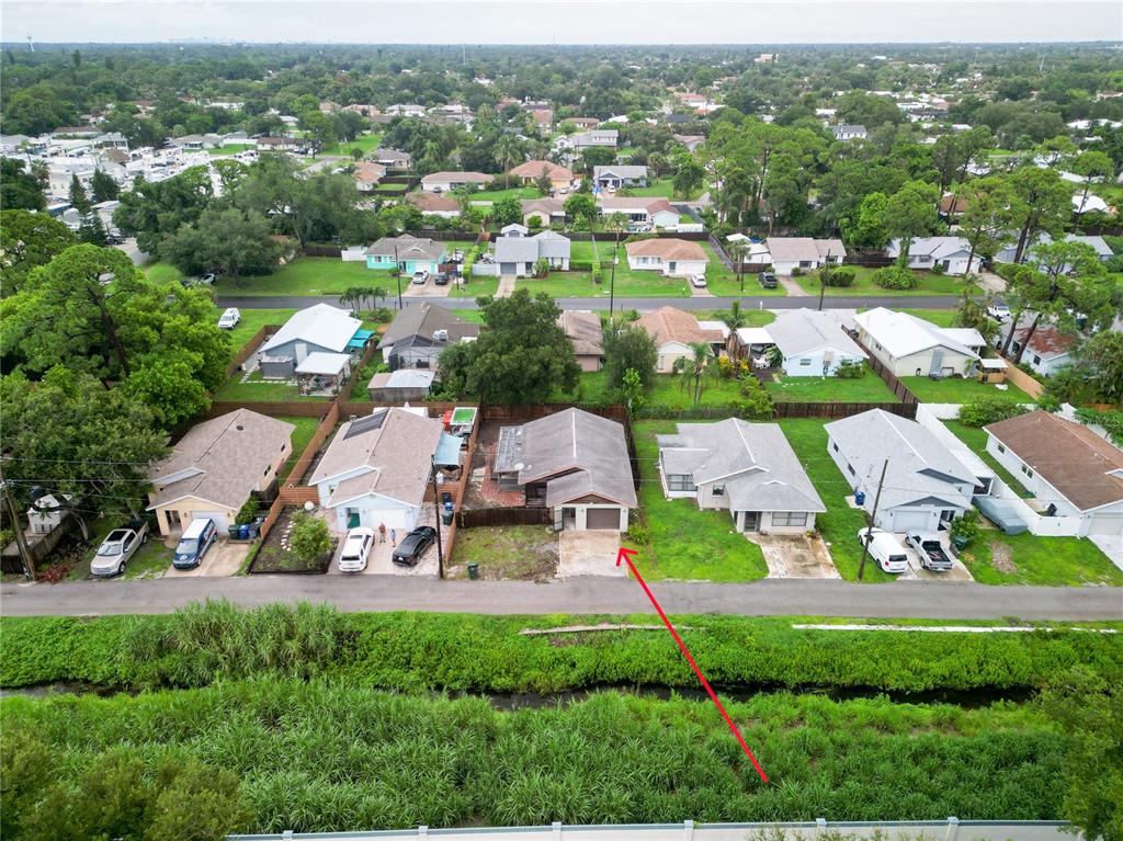 An aerial view shows a residential street with single-story houses and a red arrow pointing down — 2227 BENSON STREET, SARASOTA, FL