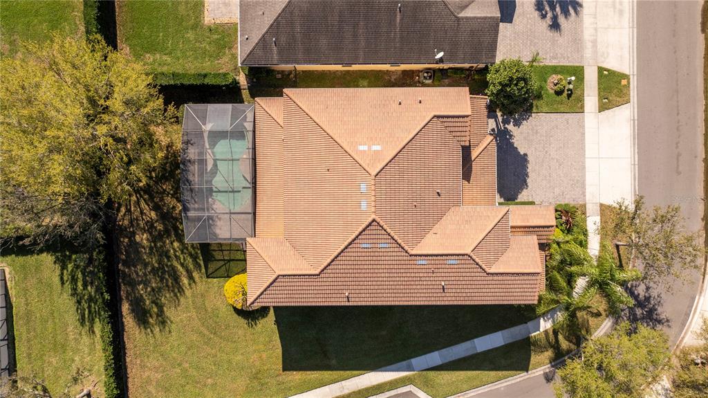 An aerial view shows a house with a tiled roof, a screened pool, and a driveway — 9442 ROYAL ESTATES BOULEVARD, ORLANDO, FL