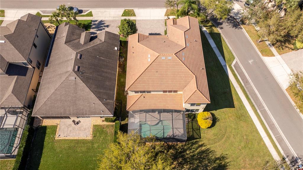 An aerial view shows two suburban houses with tile roofs, pool enclosures, and paved driveways — 9442 ROYAL ESTATES BOULEVARD, ORLANDO, FL