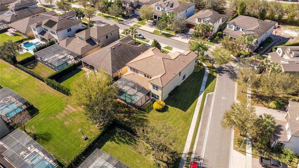 An aerial view shows a suburban neighborhood with houses, swimming pools, and paved streets — 9442 ROYAL ESTATES BOULEVARD, ORLANDO, FL